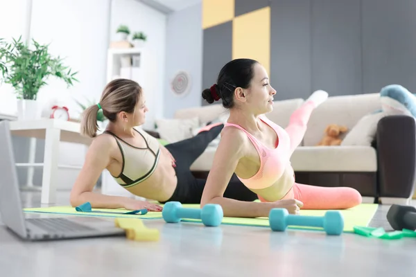 Mulheres fazendo exercícios esportivos no chão em casa — Fotografia de Stock