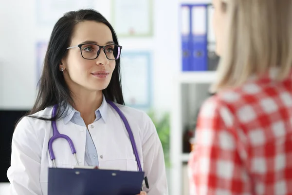 Kvinnlig läkare som kommunicerar med patienten på kliniken — Stockfoto