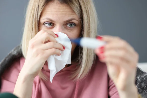 Donna malata con termometro a infrarossi e tovagliolo di carta — Foto Stock