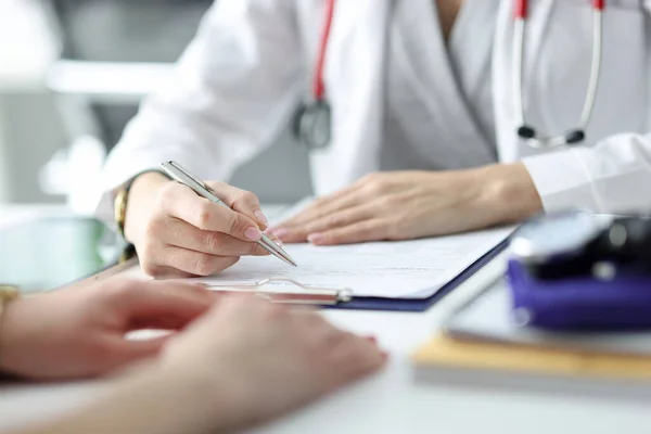 Γιατρός συμβουλεύει τον ασθενή και γράφει σε κοντινά έγγραφα — Φωτογραφία Αρχείου