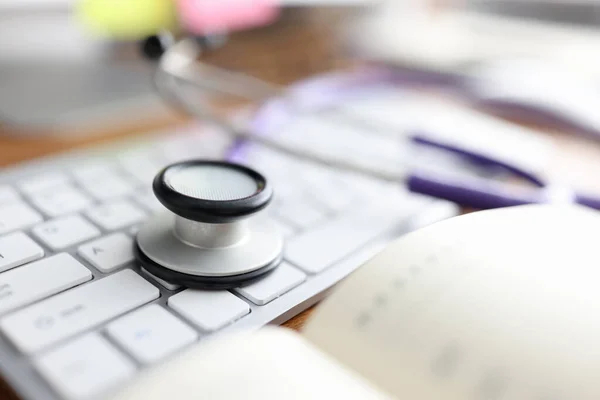 Stethoscope lying on computer keyboard in doctors office closeup — Stock Photo, Image