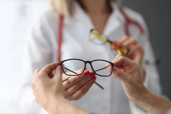 Офтальмолог предлагает пациентам очки для зрения при закрытии клиники — стоковое фото