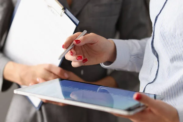 Mulher segurando estilete e tablet em suas mãos e explicando informações para colega — Fotografia de Stock