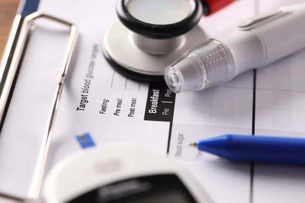 의료 문서가 들어 있는 클립보드 위에 놓여 있는 란 셋과 혈당 측정기 — 스톡 사진