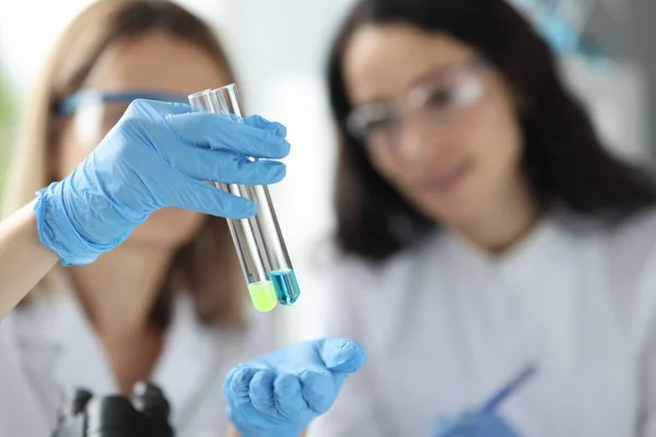 Mulheres cientistas segurando tubos de ensaio com líquido em laboratório — Fotografia de Stock