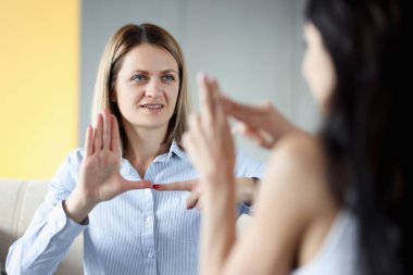 Two deaf and dumb women talking gestures at home