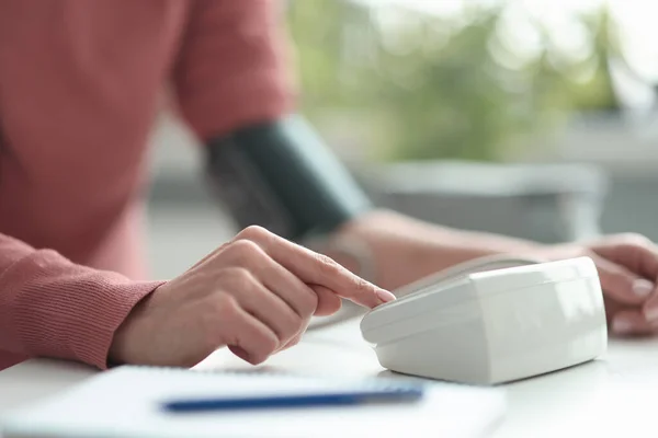 Vrouw die de bloeddruk meet met elektronische tonometer close-up — Stockfoto