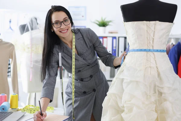Жінка швачка записує розміри весільної сукні — стокове фото