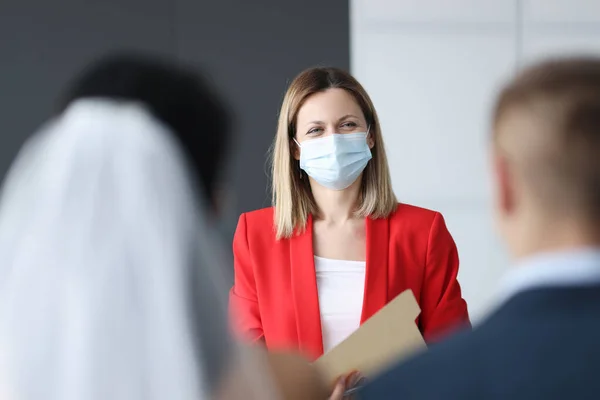 Kadının yüzünde evliliği kaydeden koruyucu tıbbi maske var. — Stok fotoğraf