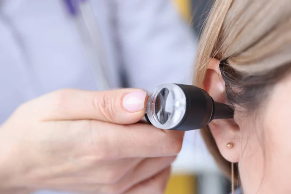 Otorhinolaryngoloog kijkt naar patiënten oor met behulp van een otoscoop close-up — Stockfoto