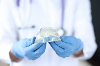 Doktorun eldivenli ellerinde silikon göğüs implantı var.