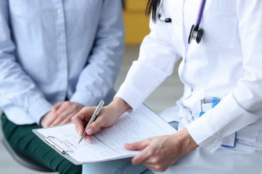 Doktor, hastaların sağlık semptomlarını karta yazar.