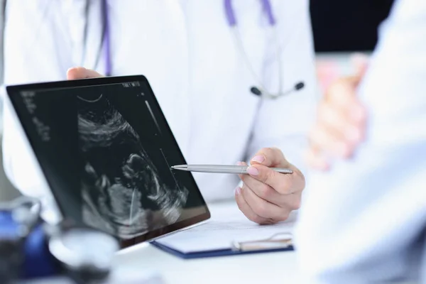 Le médecin démontre l'échographie foetale sur l'écran du comprimé — Photo