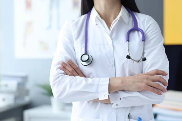 Доктор стоїть зі складеними руками на грудях в медичному кабінеті — стокове фото
