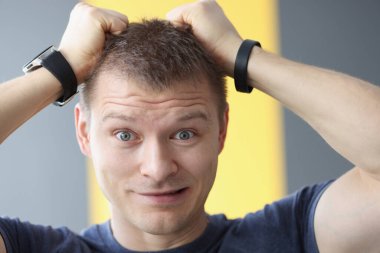 Saçını elleriyle tutan üzgün bir adamın portresi.