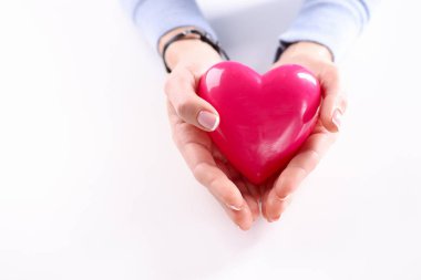 Kırmızı oyuncak kalbi tutan bir kadın.