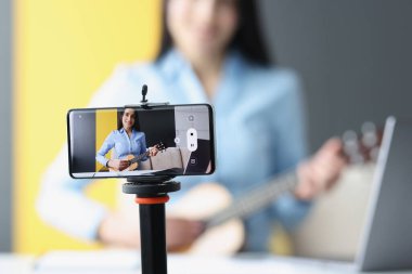 Kadın gitar dersi için yakın çekim yapıyor.