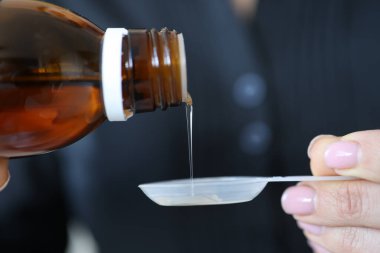 Kadınlar soğuk şurubu kaşığa döker.