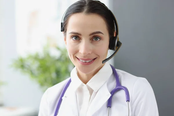 Portrait of doctor operator in headphones for remote work