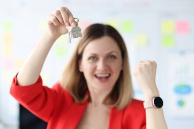 Happy smiling woman holding the keys to apartment