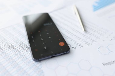 Belgelerin üzerine gizlenmiş hesap makineli cep telefonu