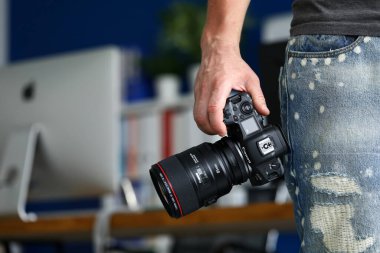 Erkek el yeni aynasız dijital kamera tutuyor Canon r5 yakın plan