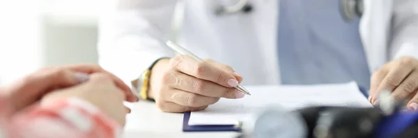 Τονόμετρο βρίσκεται στο τραπέζι των ιατρών χέρι με τους ασθενείς λαβή. — Φωτογραφία Αρχείου