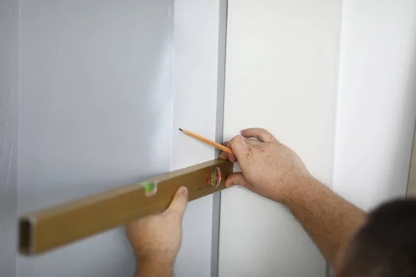 Zbliżenie profesjonalnego pracownika za pomocą poziomu ściany i ołówka — Zdjęcie stockowe