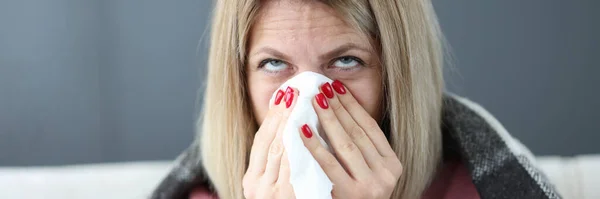Nemocná žena si vysmrká nos do kapesníku. — Stock fotografie