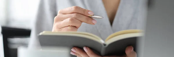 Vrouw houdt pen en een open dagboek concept — Stockfoto