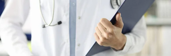 Beyaz önlüklü doktor klinikte belgeli pano tutuyor. — Stok fotoğraf