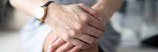 Γυναικεία χέρια με ρολόι χειρός που βρίσκεται στα γόνατα closeup — Φωτογραφία Αρχείου