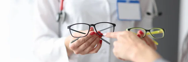 Oftalmologen visar patienten två optikpar. — Stockfoto