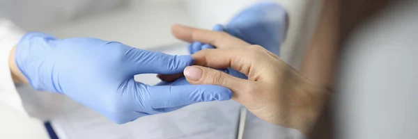 Доктор в рукавичках оглядає палець в медичному кабінеті — стокове фото