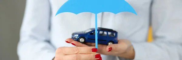 おもちゃの車と傘のクローズアップを保持する女性の手 — ストック写真