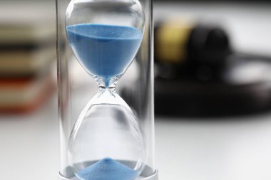 Masanın üzerinde duran mavi kumlu kum saatlerinin yakın plan görüntüsü.