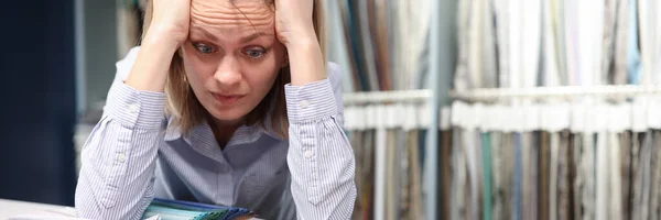 Verwirrte Frau wählt Stoffe im T-Store — Stockfoto