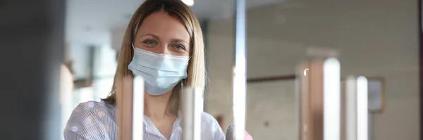 Retrato de mujer sonriente en la puerta protectora máscara médica apertura —  Fotos de Stock