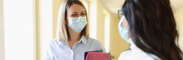 Duas empresárias em máscaras de proteção médica estão falando no escritório. — Fotografia de Stock