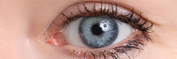 Hermoso ojo femenino azul mirando en la cámara — Foto de Stock
