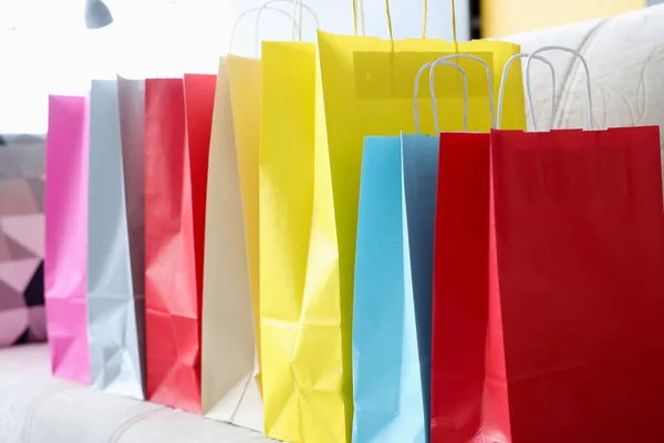 Hay bolsas de colores en el sofá después de ir de compras —  Fotos de Stock