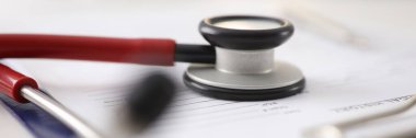 Klinikteki dosyaların üzerinde kırmızı steteskop var.