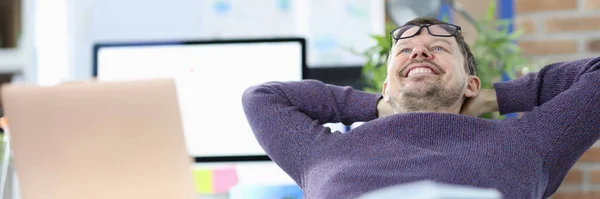 Smiling man sits at his work table — Stock Photo, Image