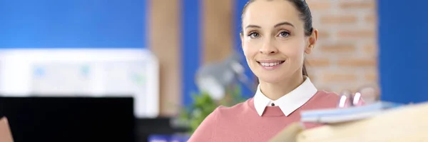 Retrato de uma mulher sorridente em uma mesa de trabalho com documentos — Fotografia de Stock