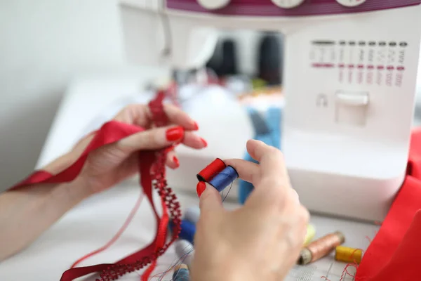 Close-up of female holding red and blue reels of thread — Stock Photo, Image