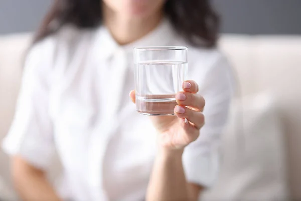 Femme tient dans sa main verre transparent d'eau — Photo