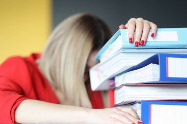 Belge klasörlerinin yanındaki yorgun kadın.