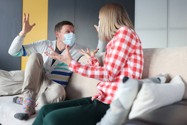 Man and woman in protective masks are fighting at home.