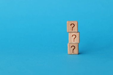 Mavi arkaplanda soru işareti olan küplerin piramidi var.