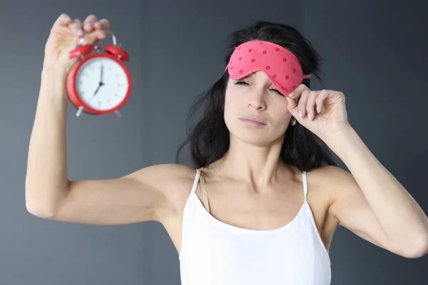 수면 마스크를 벗고 자명종 시계를 보는 여자 — 스톡 사진